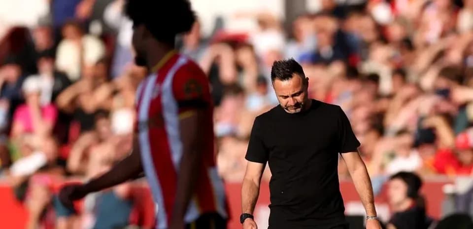 Entrenador caminando mientras jugador pasa junto a él