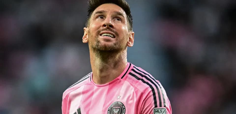 Jugador de fútbol con camiseta rosa mirando hacia arriba