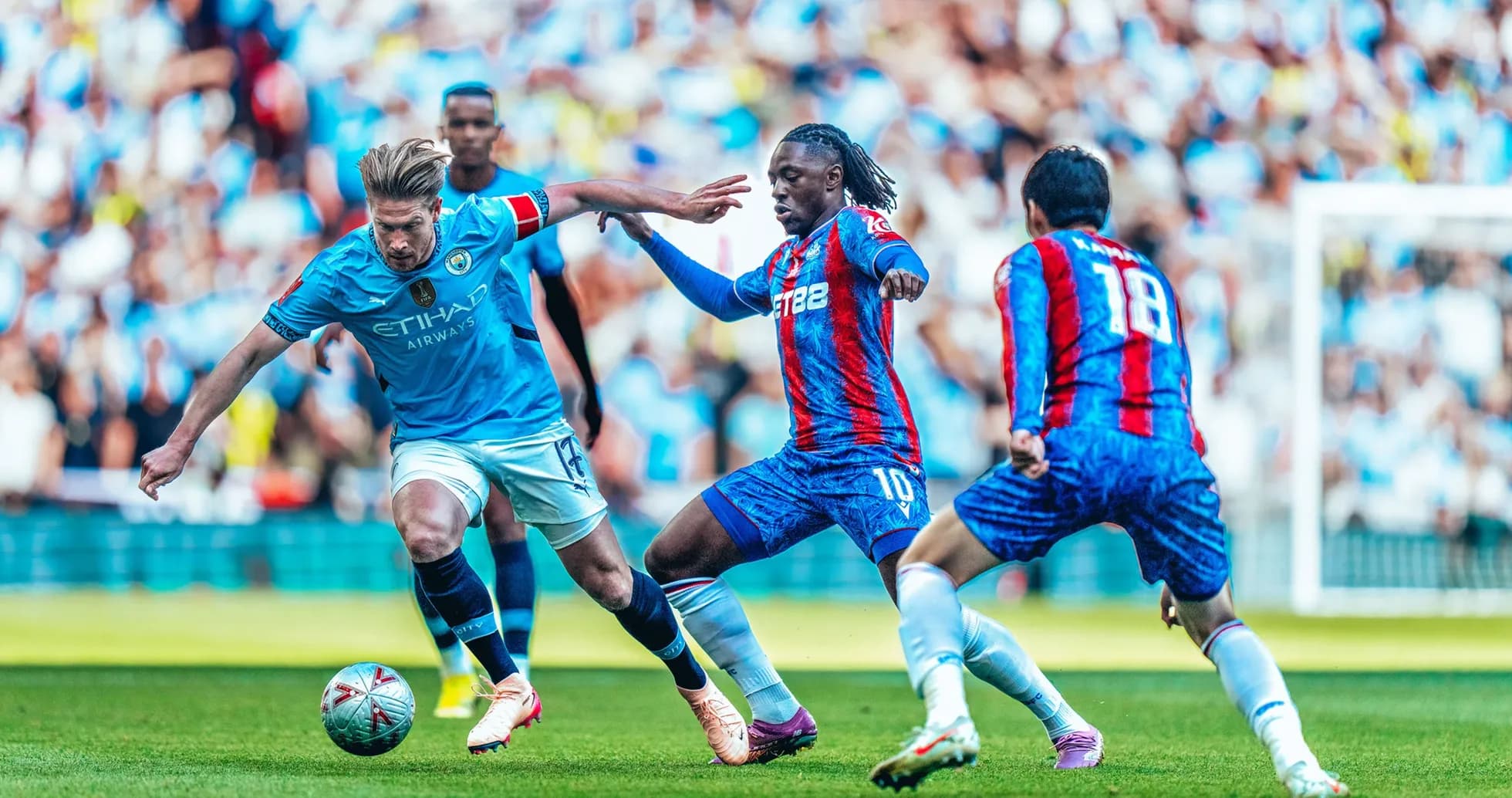 Jugador de Manchester City driblando a defensores de Crystal Palace