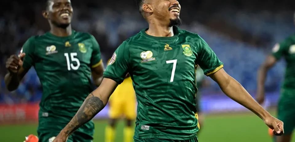 Jugador de Sudáfrica celebrando un gol con compañero