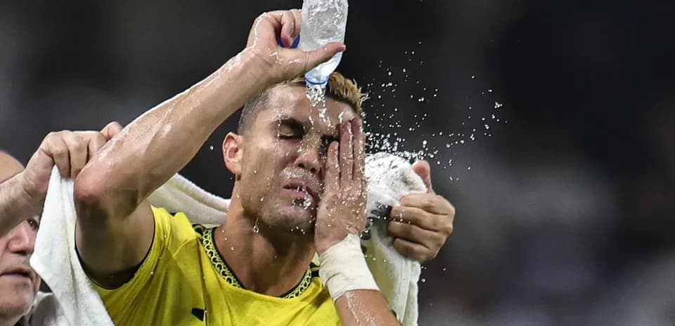 Jugador aplicando agua en su cara durante el partido