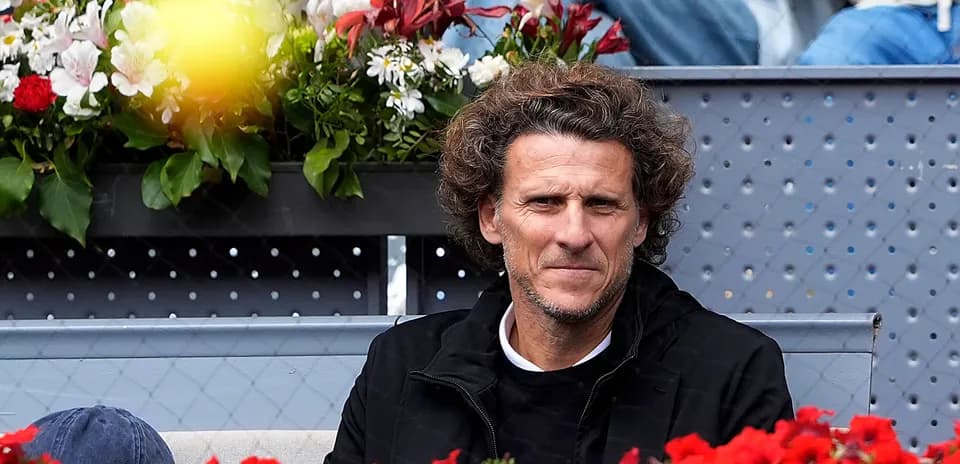Hombre sentado en gradas con flores en el fondo