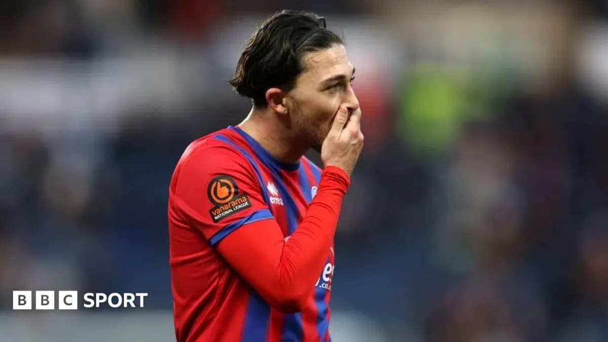 Jugador con camiseta roja tocándose la cara
