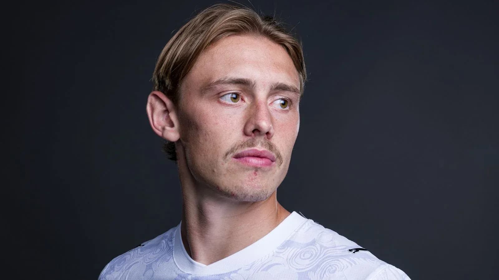 Jugador mirando hacia un lado con camiseta blanca