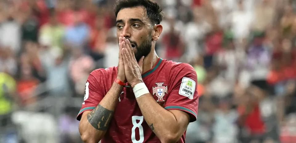 Jugador de Portugal con camiseta roja, manos en la cara