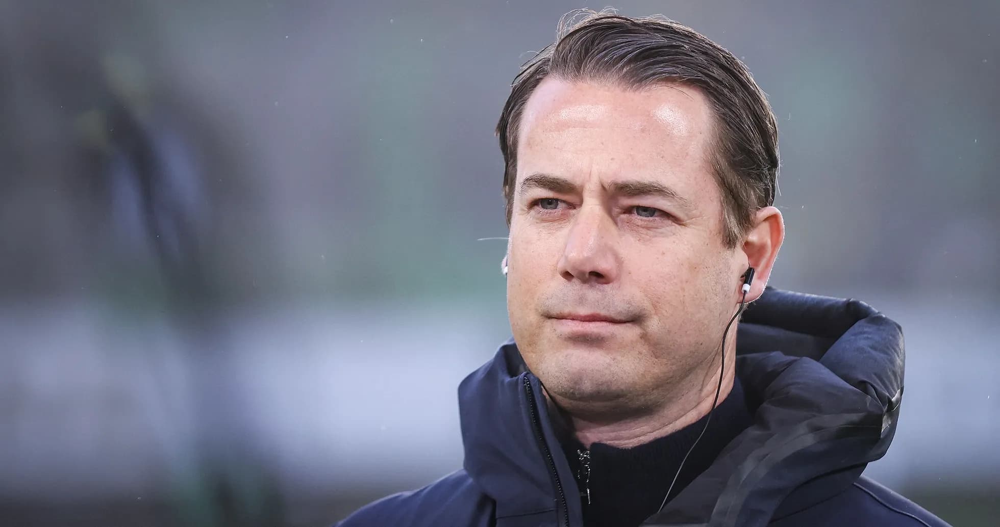 Entrenador en la cancha con auriculares puestos