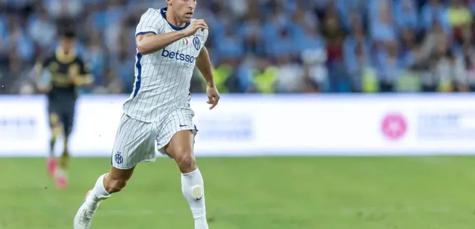 Jugador corriendo con balón en el campo de fútbol