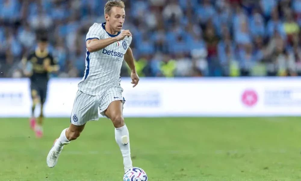Jugador corriendo con balón en el campo de fútbol