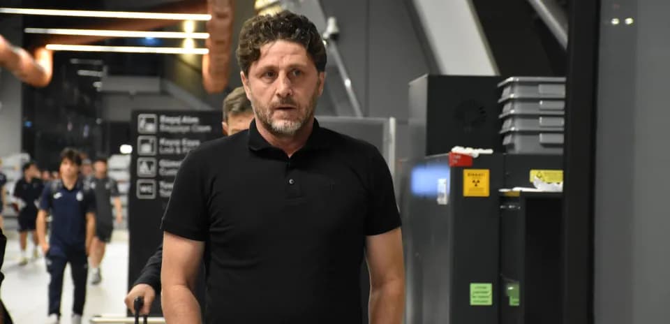Entrenador caminando en el aeropuerto con equipo