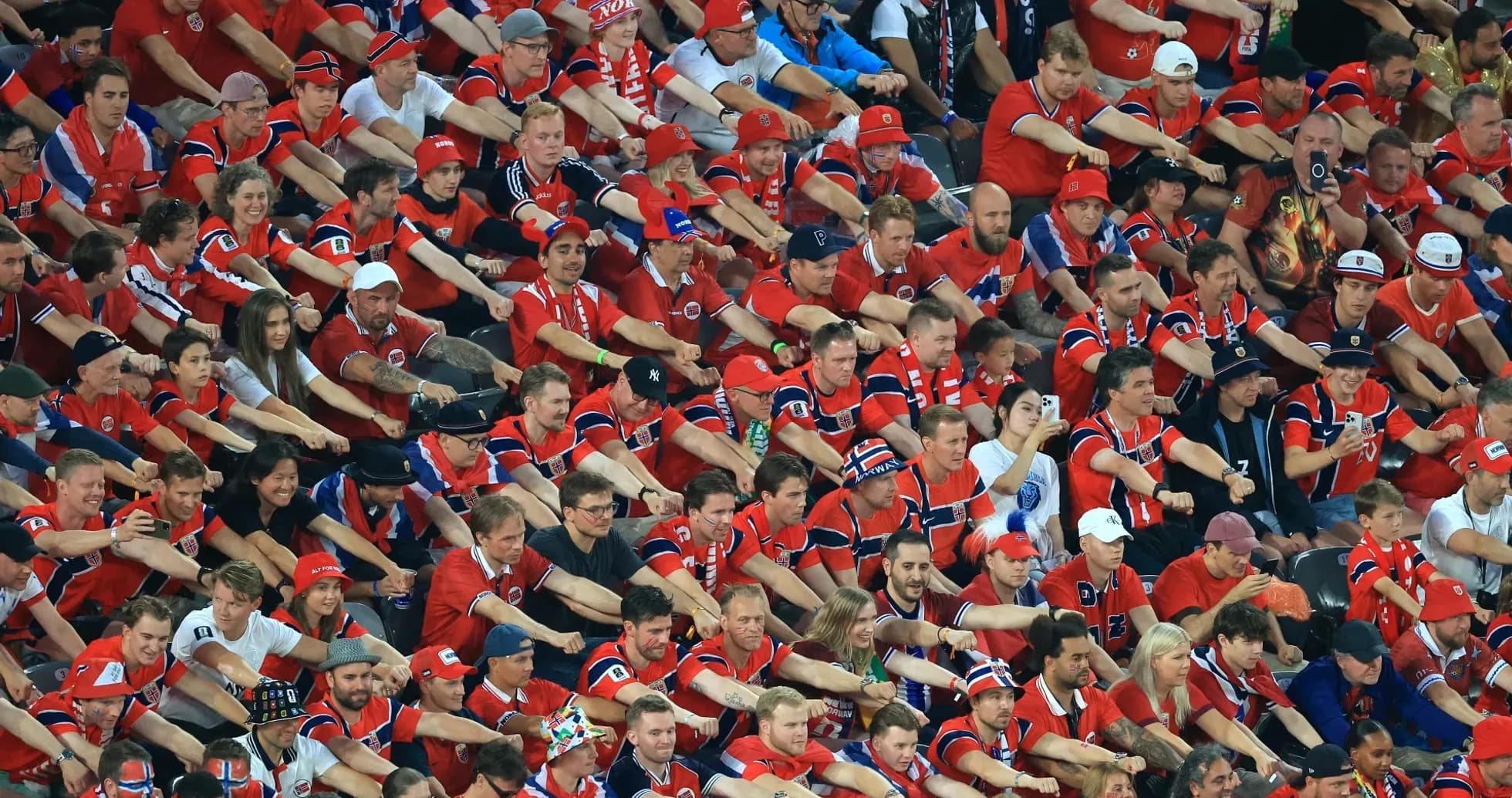 Aficionados animando en un estadio, vestidos de rojo