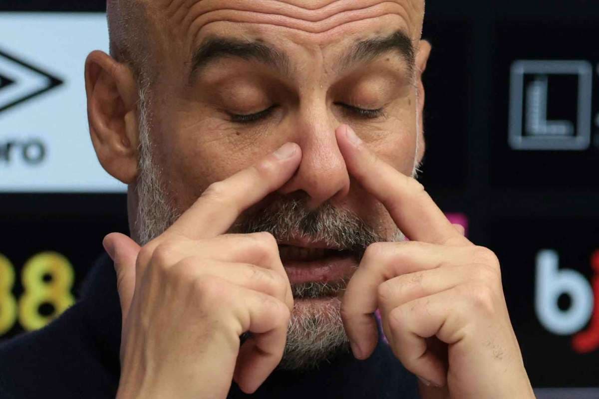Entrenador ajustando sus gafas en conferencia de prensa