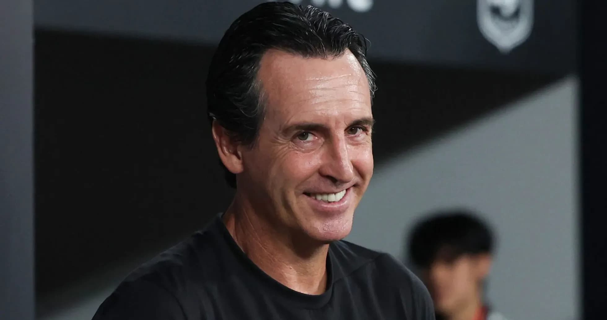 Entrenador sonriendo en la zona técnica
