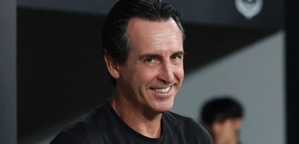 Entrenador sonriendo en la zona técnica