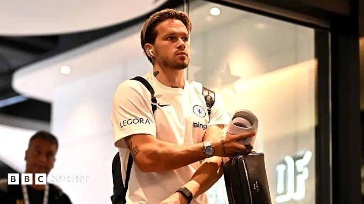 Jugador de Chelsea llegando con auriculares y maleta