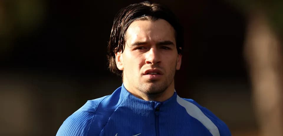 Jugador entrenando con chaqueta azul en el campo