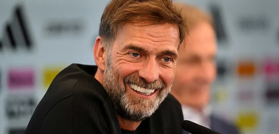 Entrenador sonriendo durante una conferencia de prensa