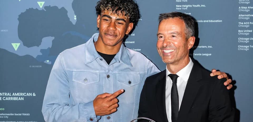 Dos hombres posando en evento con mapa de fondo