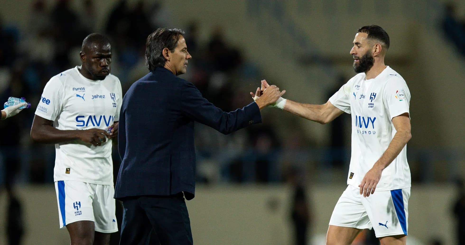 Entrenador saludando a jugador durante el partido