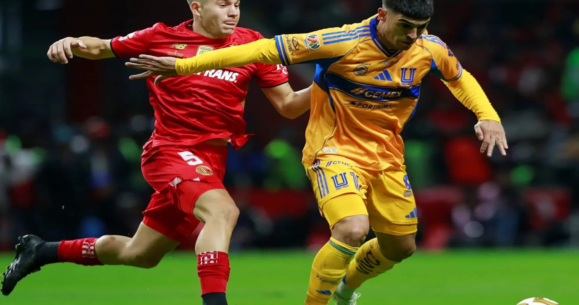 Jugadores de Toluca y Tigres compitiendo por el balón