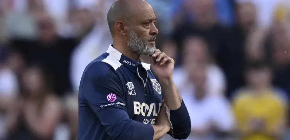 Entrenador observando el partido con gesto pensativo