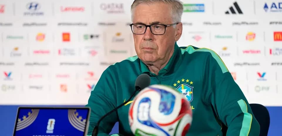 Entrenador en conferencia de prensa con balón frente