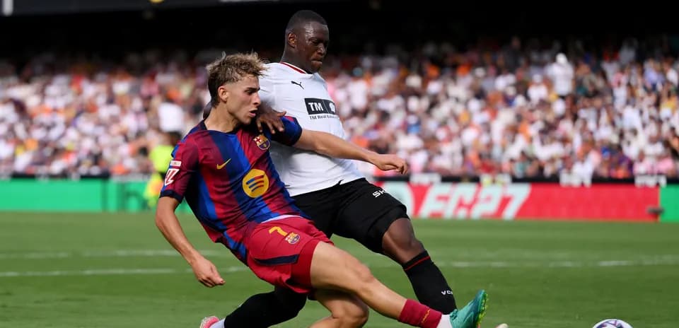 Jugador de Barcelona deslizándose para interceptar balón