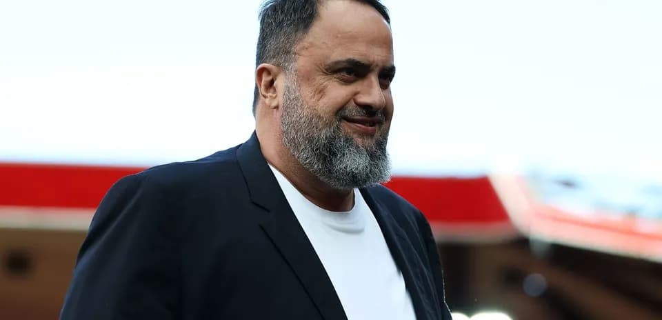 Hombre con barba sonriendo en un estadio