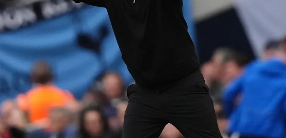 Entrenador gesticulando durante un partido de fútbol