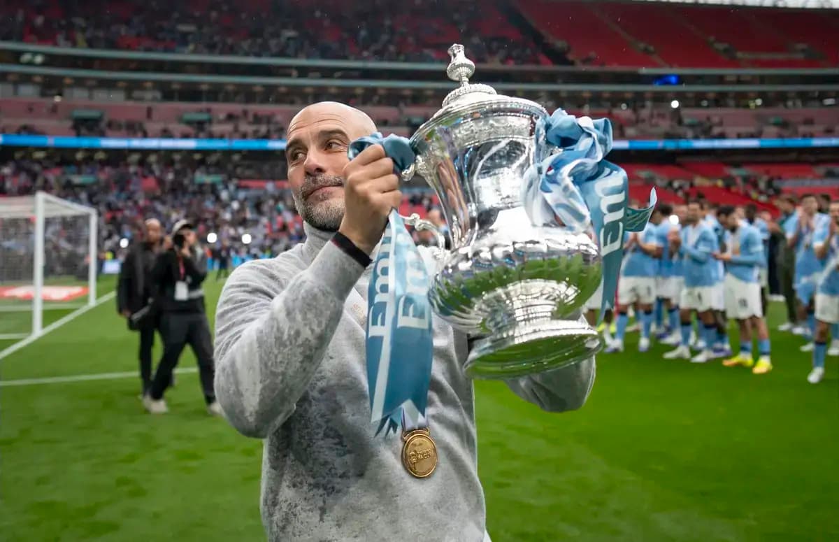Entrenador sosteniendo trofeo en el campo de Wembley