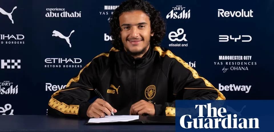 Jugador firmando contrato en mesa de prensa