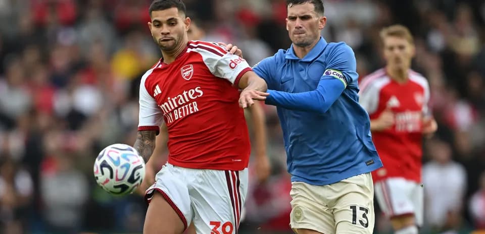Jugador de Arsenal luchando por el balón con oponente
