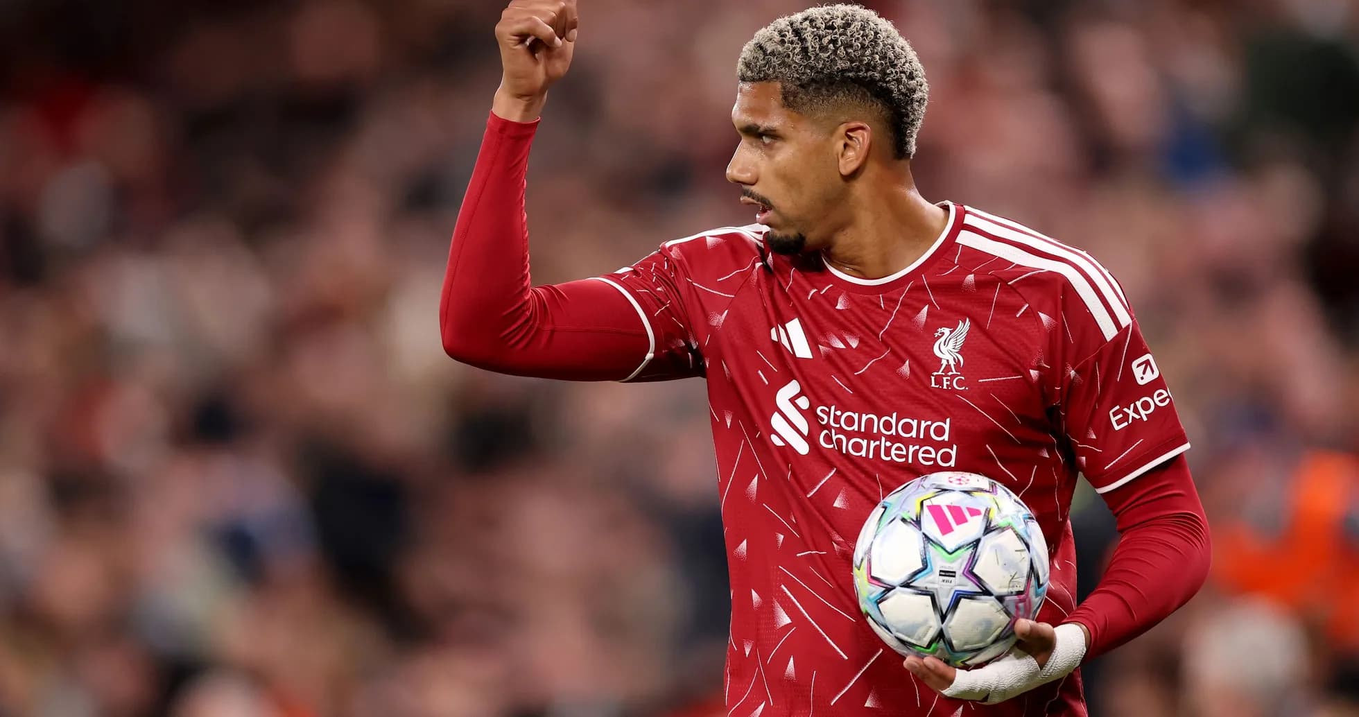 Jugador de Liverpool levantando la mano con el balón
