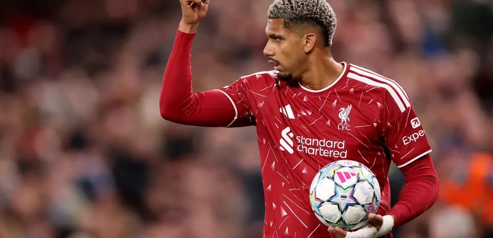 Jugador de Liverpool levantando la mano con el balón