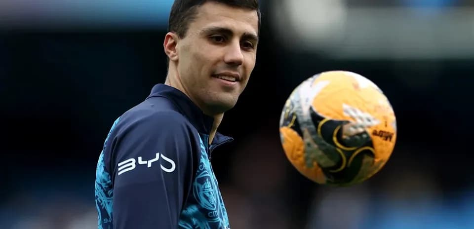 Jugador sosteniendo un balón de fútbol en entrenamiento