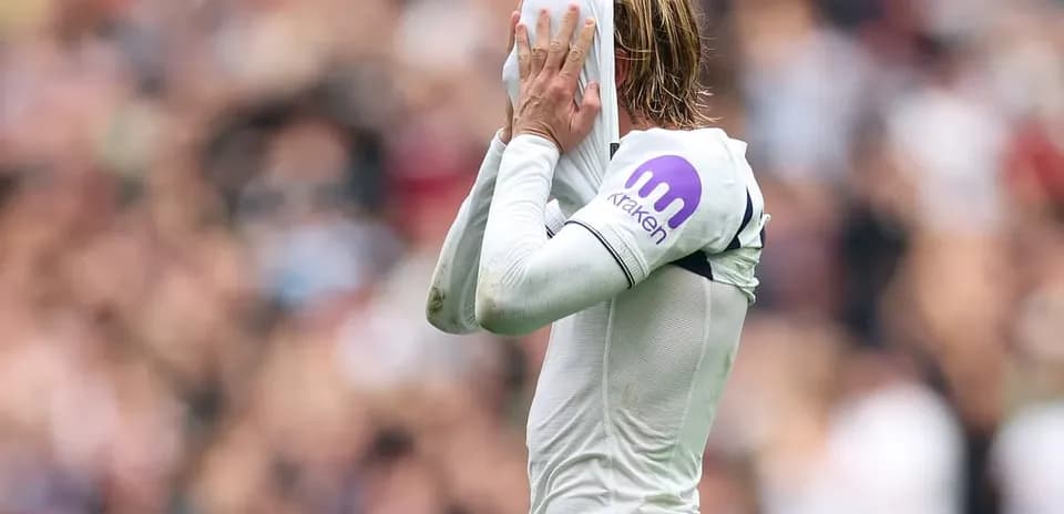 Jugador cubriendo su rostro con la camiseta durante partido