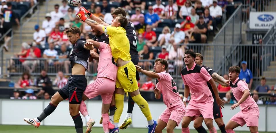 Portero saltando para atrapar el balón en partido