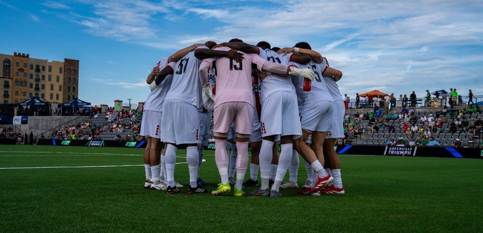 Jugadores del Greenville Triumph en un círculo