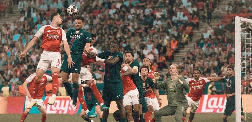 Jugadores saltando por un balón en el área