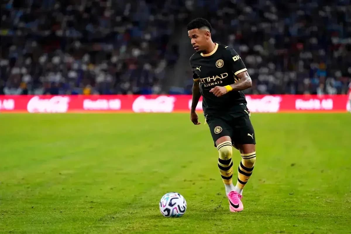 Jugador de fútbol corriendo con balón en el campo