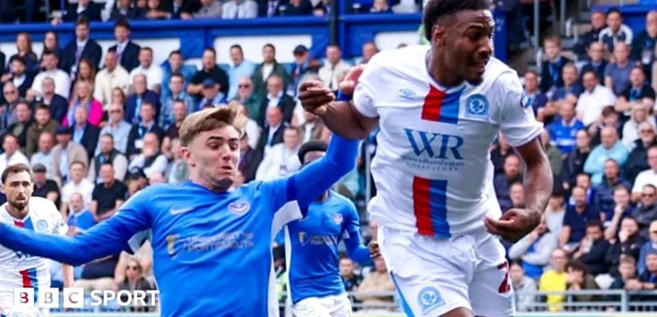Jugador en camiseta blanca driblando a oponente en azul