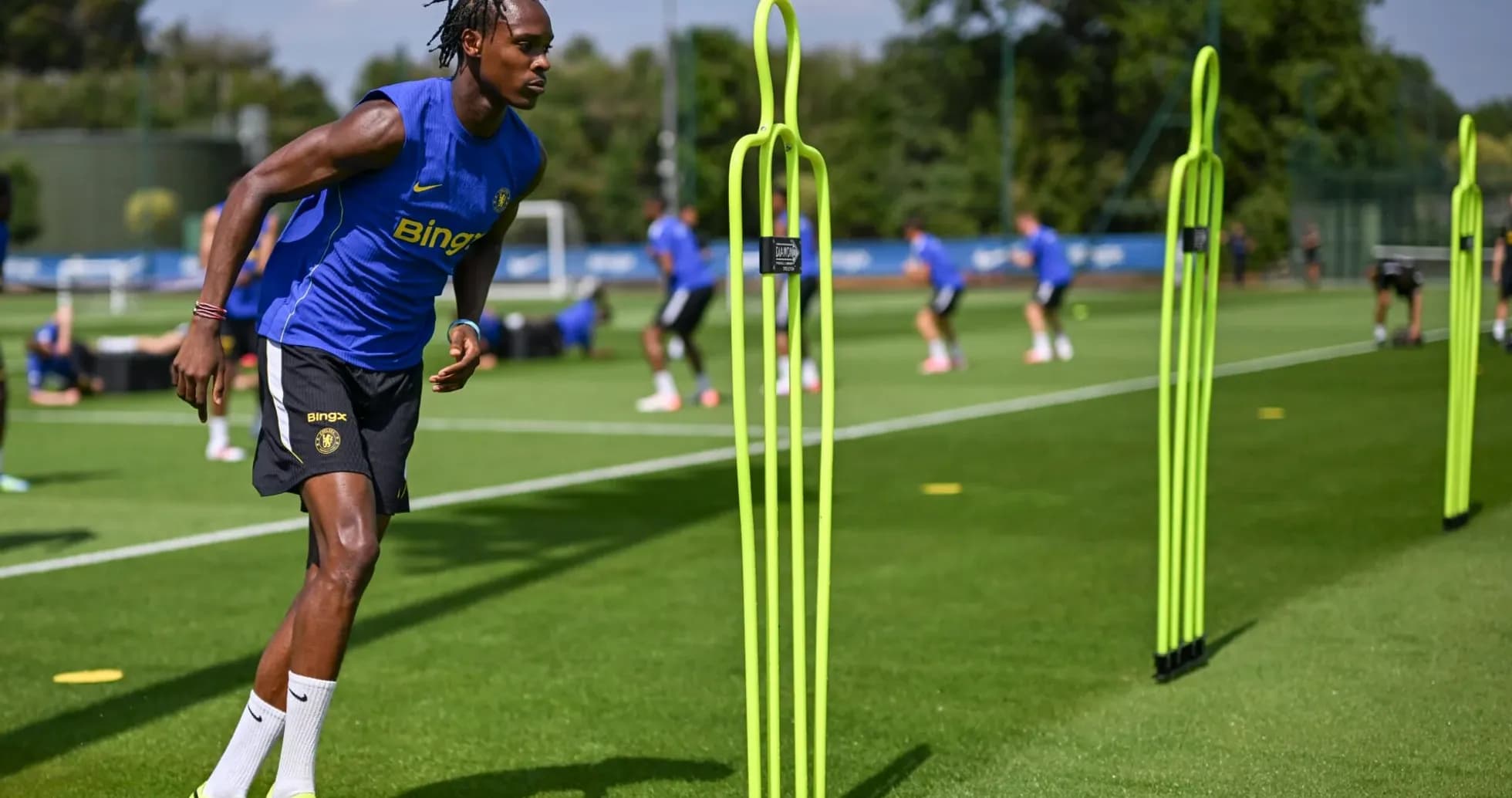 Jugador entrenando en el campo con conos de entrenamiento