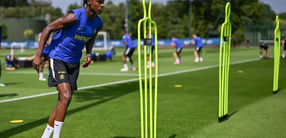 Jugador entrenando en el campo con conos de entrenamiento