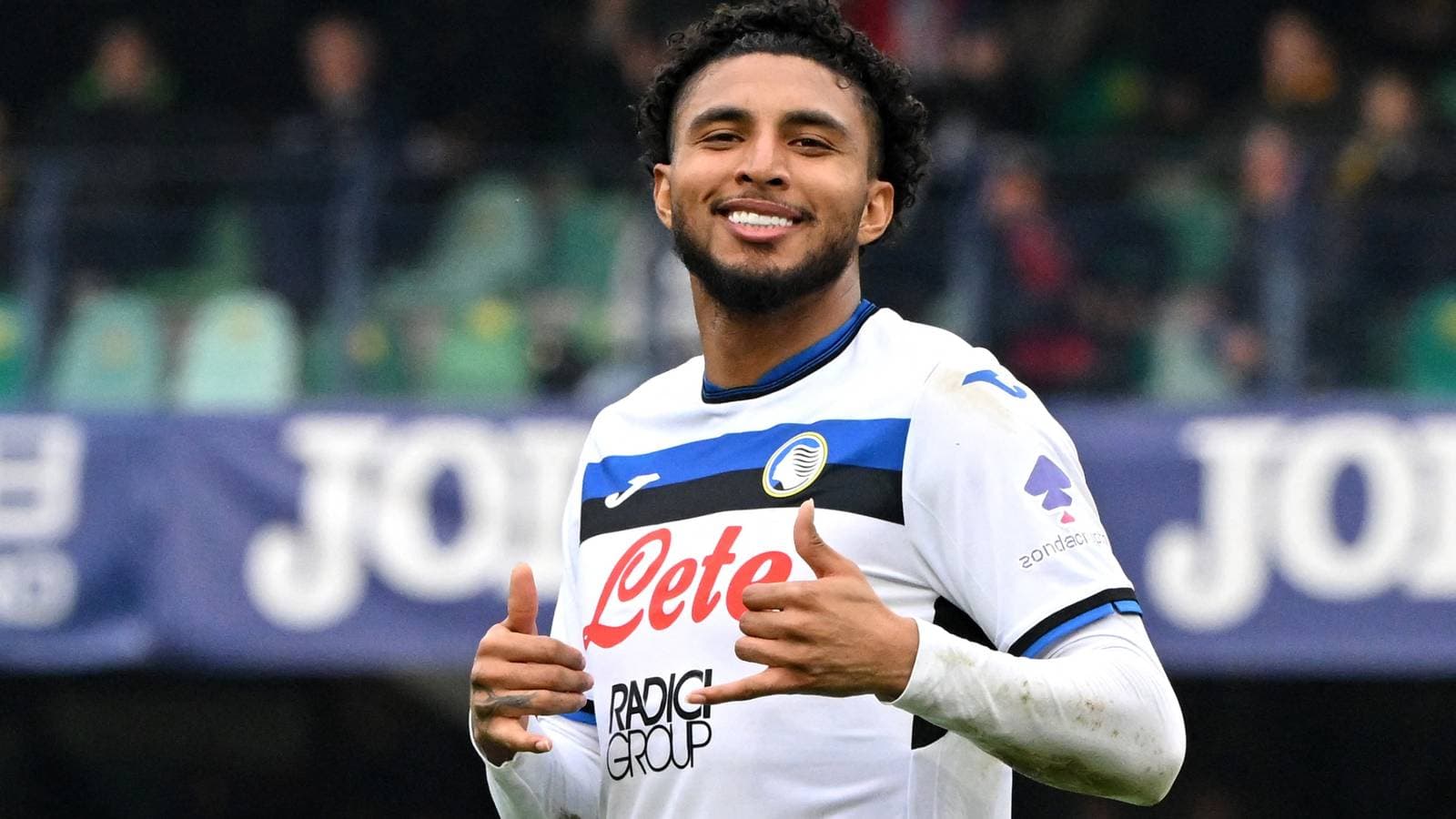 Jugador de Atalanta sonriendo y haciendo gestos en el campo