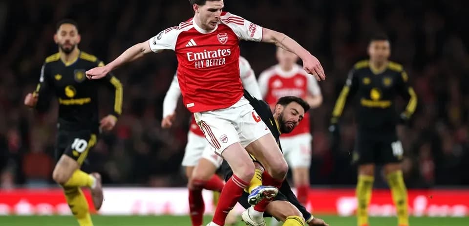 Jugador de Arsenal esquivando a oponente en el campo