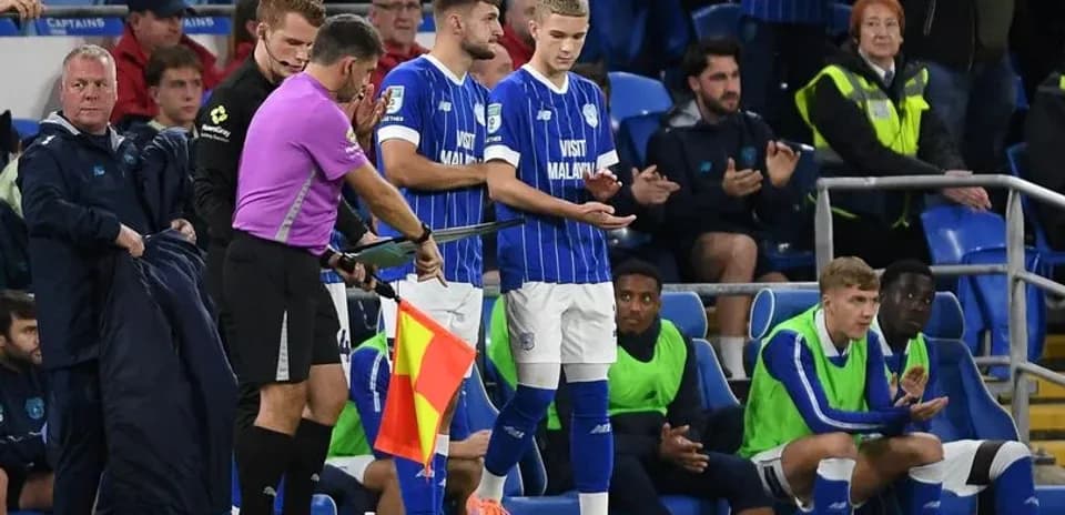 Jugador siendo sustituido en el banquillo del partido