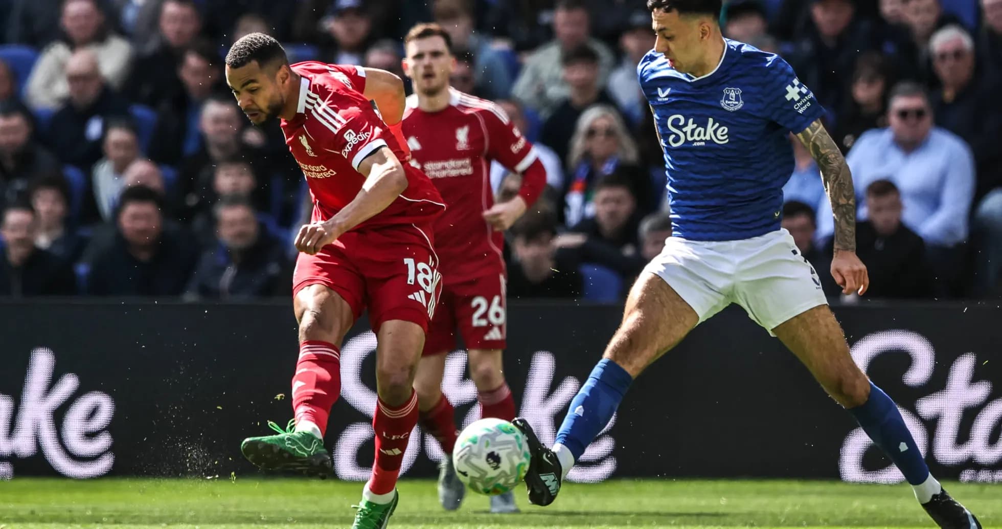 Jugador de Liverpool driblando contra defensor de Everton