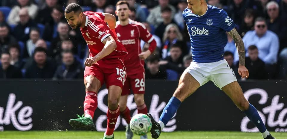 Jugador de Liverpool driblando contra defensor de Everton