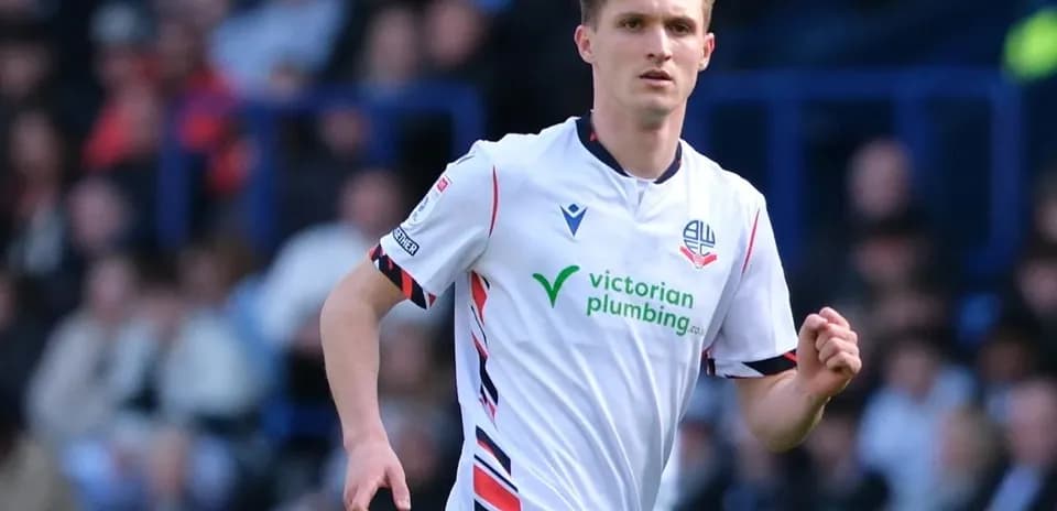 Jugador de Bolton Wanderers corriendo en el campo
