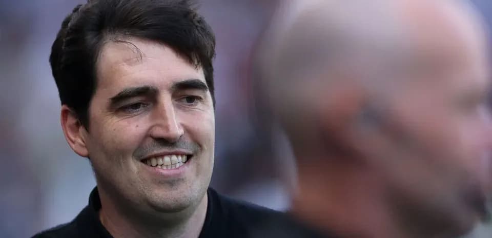 Entrenador sonriendo en el campo durante el partido