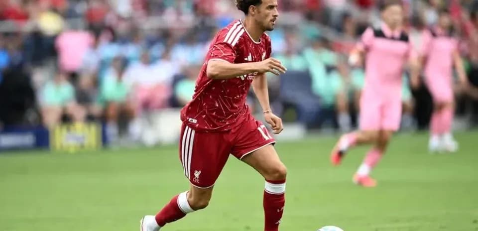 Jugador de Liverpool corriendo con el balón en campo